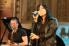 Die Sängerin Stefanie Kloß singt während eines Konzerts, im Hintergrund ist David Klein zu sehen, diesmal aus einem anderen Winkel